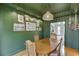 Elegant dining room featuring green walls, natural lighting, and a stylish chandelier at 3852 Old Bridge Way, Duluth, GA 30096