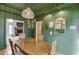 Elegant dining room featuring green walls, natural lighting, and a stylish chandelier at 3852 Old Bridge Way, Duluth, GA 30096