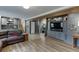 Open-concept living room with built-in cabinets, dark brown leather furniture, and wood-look flooring at 3852 Old Bridge Way, Duluth, GA 30096