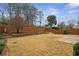 Large backyard featuring a spacious lawn, wooden fence, and tiered garden beds at 6445 Glen Oaks Ln, Atlanta, GA 30328