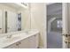 Bathroom with double sinks, a mirror, and an open doorway revealing another bedroom at 6445 Glen Oaks Ln, Sandy Springs, GA 30328