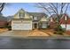 Attractive two-story home with a two-car garage, stone accents, and manicured landscaping at 6445 Glen Oaks Ln, Sandy Springs, GA 30328