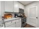 Well-equipped kitchen featuring stainless steel appliances, marble countertops, and white cabinets, designed for culinary enthusiasts at 100 Biscayne Nw Dr # E1, Atlanta, GA 30309