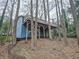 Unique blue home featuring a large, wooden deck supported by sturdy beams and nestled among mature trees at 2336 Vistamont Dr, Decatur, GA 30033