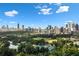 A scenic view of the city skyline over lush green trees and a pond at 40 12Th Ne St # 1503, Atlanta, GA 30309