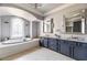 Elegant bathroom featuring a soaking tub, marble countertops, and decorative mirrors at 6955 Laurel Oak Dr, Suwanee, GA 30024