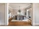 Elegant dining room featuring hardwood floors, decorative pillars, and a modern light fixture at 6955 Laurel Oak Dr, Suwanee, GA 30024