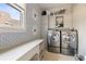 Laundry room featuring a side-by-side washer and dryer, built-in cabinets and patterned wallpaper at 6955 Laurel Oak Dr, Suwanee, GA 30024