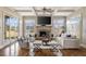 Comfortable living room showcasing a stone fireplace, neutral furniture, and French doors for bright natural light at 6955 Laurel Oak Dr, Suwanee, GA 30024