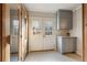 Mudroom with grey cabinetry, double french doors, and tile flooring at 6955 Laurel Oak Dr, Suwanee, GA 30024