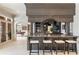 Wet bar featuring granite countertops, a wooden bar structure, and views of the adjoining rooms at 6955 Laurel Oak Dr, Suwanee, GA 30024