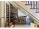 Well-stocked wine cellar under the staircase with wooden wine racks and a glass wall at 6955 Laurel Oak Dr, Suwanee, GA 30024