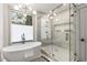 A luxurious bathroom featuring an oval tub, glass shower, and a modern light fixture at 1055 Ormewood Se Ave, Atlanta, GA 30316