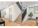 Bright staircase with modern wood and black iron railing, complemented by designer paint and hardwood flooring at 1055 Ormewood Se Ave, Atlanta, GA 30316