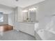 Comfortable bathroom offers a double vanity, bathtub, and modern lighting fixtures at 1429 Christiana Dr, Lawrenceville, GA 30043