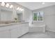 Elegant bathroom featuring double sinks, a soaking tub, and ample natural light at 1429 Christiana Dr, Lawrenceville, GA 30043