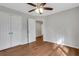 This bedroom features hardwood floors, neutral paint, ceiling fan, closet and door at 1429 Christiana Dr, Lawrenceville, GA 30043
