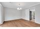 Dining room featuring hardwood floors, elegant lighting fixture, and view into kitchen at 1429 Christiana Dr, Lawrenceville, GA 30043