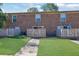 Townhome with a brick exterior, wooden fence, and well-maintained lawn at 5678 Kingsport Dr, Sandy Springs, GA 30342