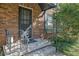 Close-up view of the front door and porch area of a brick townhome with black shutters at 5678 Kingsport Dr, Sandy Springs, GA 30342