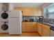 Cozy kitchen with wooden cabinets, and stainless steel appliances, including a washer and dryer at 5678 Kingsport Dr, Sandy Springs, GA 30342