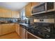 Kitchen with stainless steel microwave and range oven against black counters at 5678 Kingsport Dr, Sandy Springs, GA 30342