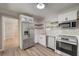 Bright kitchen features stainless steel appliances, white cabinets, subway tile backsplash, and wood-look flooring at 2493 Woodacres Ne Rd, Atlanta, GA 30345