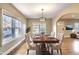 Dining room with a large window, a decorative chandelier, and a table set for six, virtually staged at 958 Winburn Dr, East Point, GA 30344