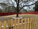 Fenced-in backyard featuring a large tree surrounded by stone and a separate fenced-in pet area at 3038 Mary Alice Trl, Loganville, GA 30052