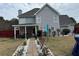 Exterior view of a grey two-story home featuring a covered patio and landscaped backyard at 3038 Mary Alice Trl, Loganville, GA 30052