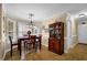 This dining room has a wooden table set next to a big window, hardwood floors, and a wooden china cabinet at 777 Glen Valley Way, Dacula, GA 30019