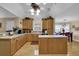 Open kitchen featuring light wood cabinetry, an island, stainless steel appliances, and a view to a sunlit dining area at 777 Glen Valley Way, Dacula, GA 30019