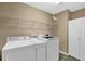 Functional laundry room with washer, dryer, storage cabinets, and ample shelving at 777 Glen Valley Way, Dacula, GA 30019