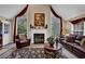 This cozy living room is styled with an elegant fireplace, plush furniture, and large windows offering a serene view at 777 Glen Valley Way, Dacula, GA 30019