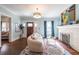 Open living room with hardwood floors, white fireplace, and dark wood front door at 902 E Ponce De Leon Ave, Decatur, GA 30030