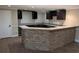 Basement bar with stone accents, granite countertops and wood cabinetry at 4401 Riverlake Way, Snellville, GA 30039