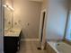 Spacious bathroom with tub, tile floor, single vanity and large mirror offers a nice retreat at 4401 Riverlake Way, Snellville, GA 30039