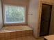 This bathroom has a glass-door shower, tub, and large window for a bright, refreshing space at 4401 Riverlake Way, Snellville, GA 30039