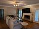 Open living room with fireplace, ceiling fan, hardwood floors, and lots of light at 4401 Riverlake Way, Snellville, GA 30039