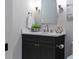 Elegant powder room featuring a black vanity with marble countertop and arched mirror at 660 Timm Valley Ne Rd, Atlanta, GA 30305