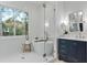 Modern bathroom with a soaking tub, glass-enclosed shower, and navy blue vanity at 660 Timm Valley Ne Rd, Atlanta, GA 30305