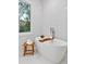 Relaxing soaking tub with a scenic view and modern fixtures in a tiled bathroom at 660 Timm Valley Ne Rd, Atlanta, GA 30305