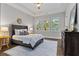Cozy bedroom featuring tray ceilings, hardwood floors, and three large windows at 660 Timm Valley Ne Rd, Atlanta, GA 30305