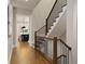 Inviting hallway with hardwood floors, staircase with black railing, and view into the kitchen at 660 Timm Valley Ne Rd, Atlanta, GA 30305
