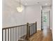 Upstairs hallway featuring hardwood floors, stylish lighting and a glimpse of outdoors at 660 Timm Valley Ne Rd, Atlanta, GA 30305