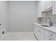 Bright laundry room featuring white cabinets, countertops, and modern fixtures at 660 Timm Valley Ne Rd, Atlanta, GA 30305