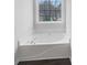 Bathroom with a large soaking tub with chrome fixtures, a window with backyard views, and hardwood floors at 5132 Silhouette Sw Ln, Mableton, GA 30126