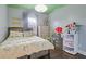 A cozy bedroom featuring hardwood floors, soft yellow bedding, and an accent painted ceiling with stylish light fixture at 3374 Grey St, Duluth, GA 30096