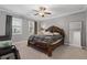 Bedroom with a ceiling fan, a window, carpeting, and a bed with decorative headboard, plus a large floor mirror at 3374 Grey St, Duluth, GA 30096