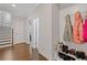 An inviting hallway with hardwood floors, featuring a charming mudroom area with hooks, a bench, and shoe storage at 3374 Grey St, Duluth, GA 30096